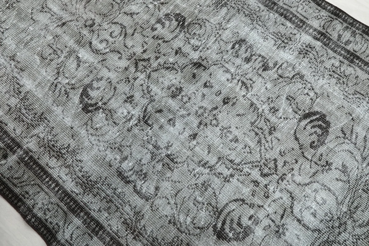 Detailed view of the distressed gray field and charcoal floral patterns