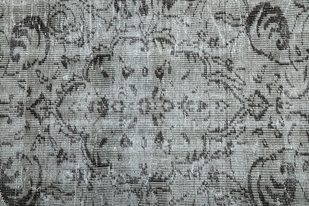Close-up of the low wool pile and intricate knotting of the vintage rug