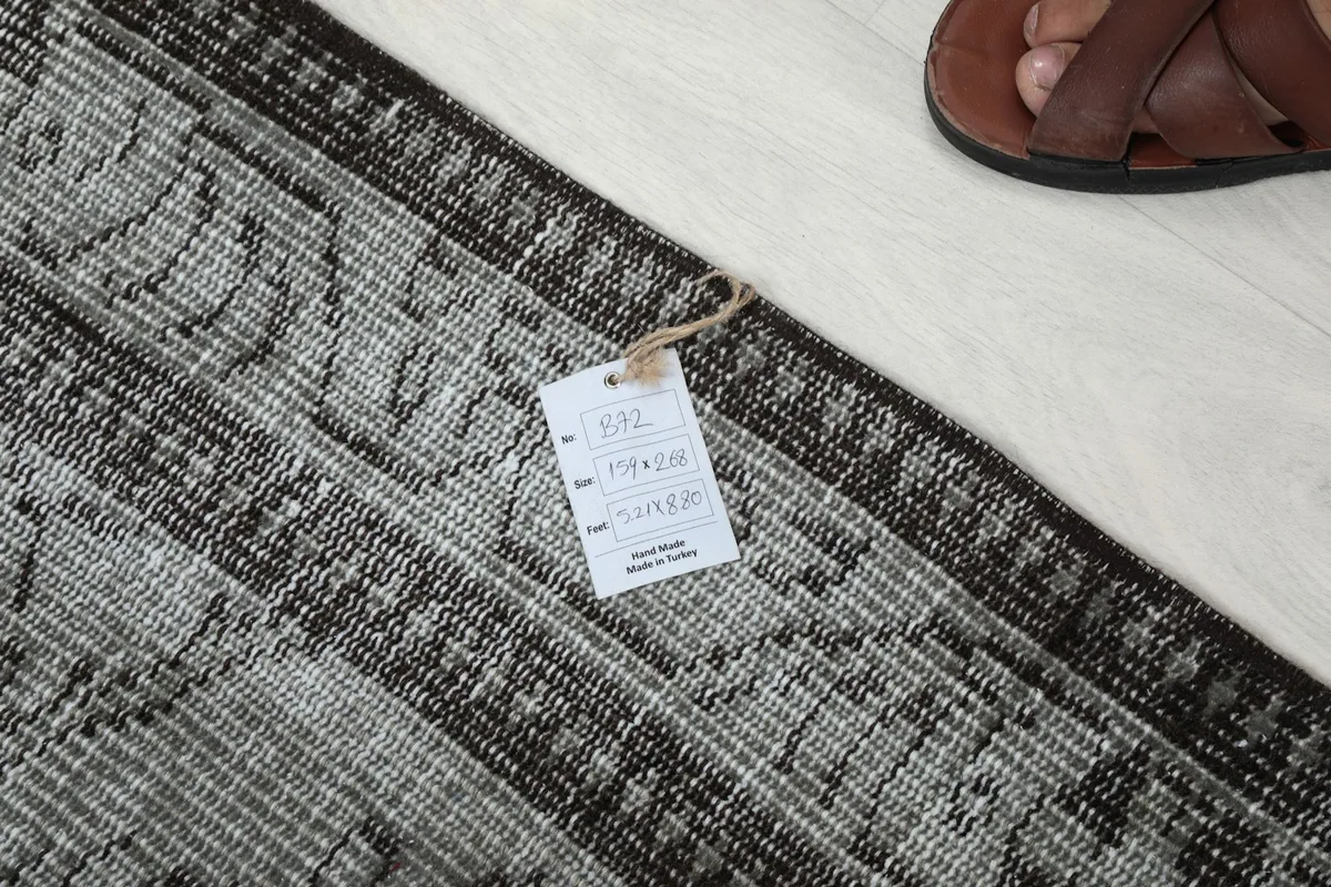 Tag displaying rug dimensions and origin, placed on the rug's border