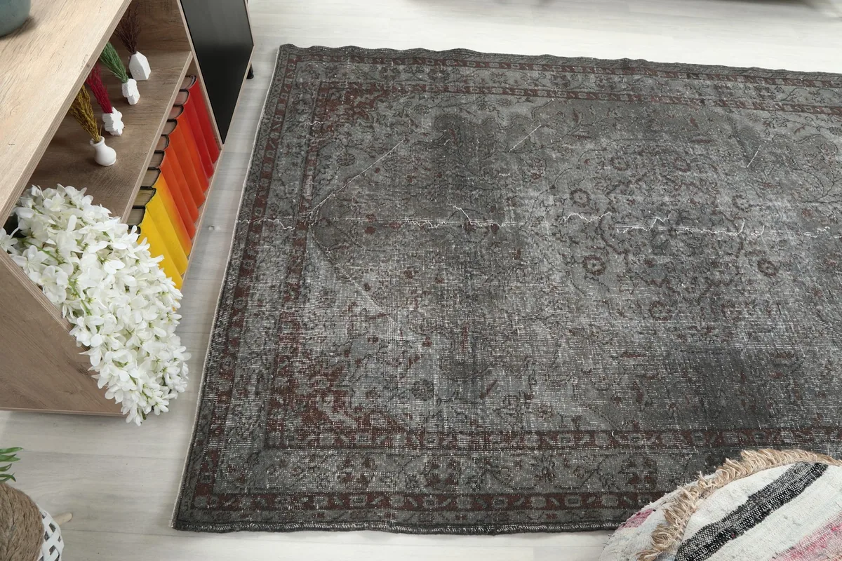 Angle view of the rug's surface, revealing the interplay of charcoal, gray, and rust colors.