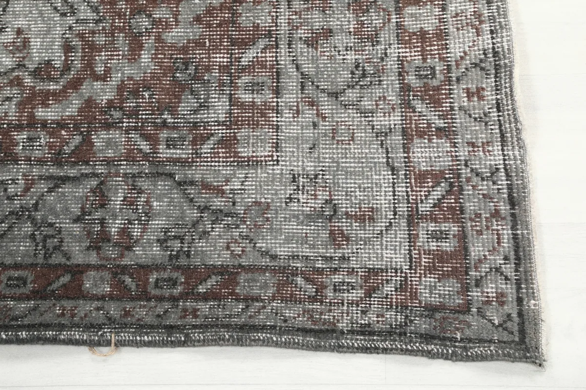 Detailed view of the rug's corner, highlighting the intricate patterns and wool pile texture.