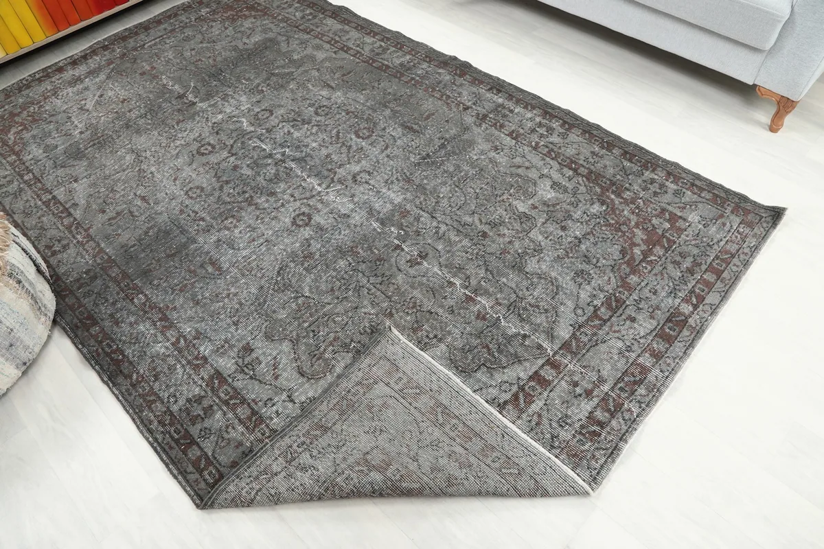 View of the rug folded back to show the reverse side and the hand-knotted cotton foundation.