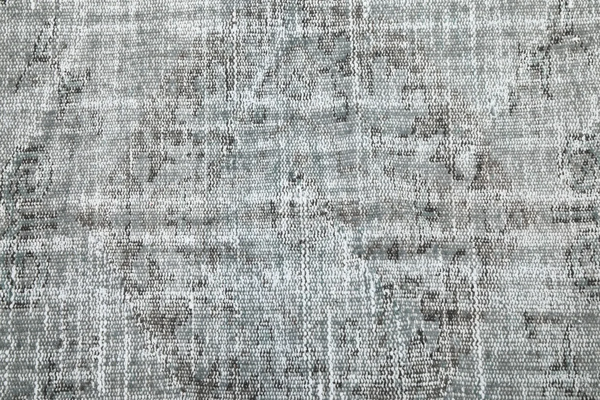 Close-up of the rug's surface, highlighting the distressed appearance and faint patterns