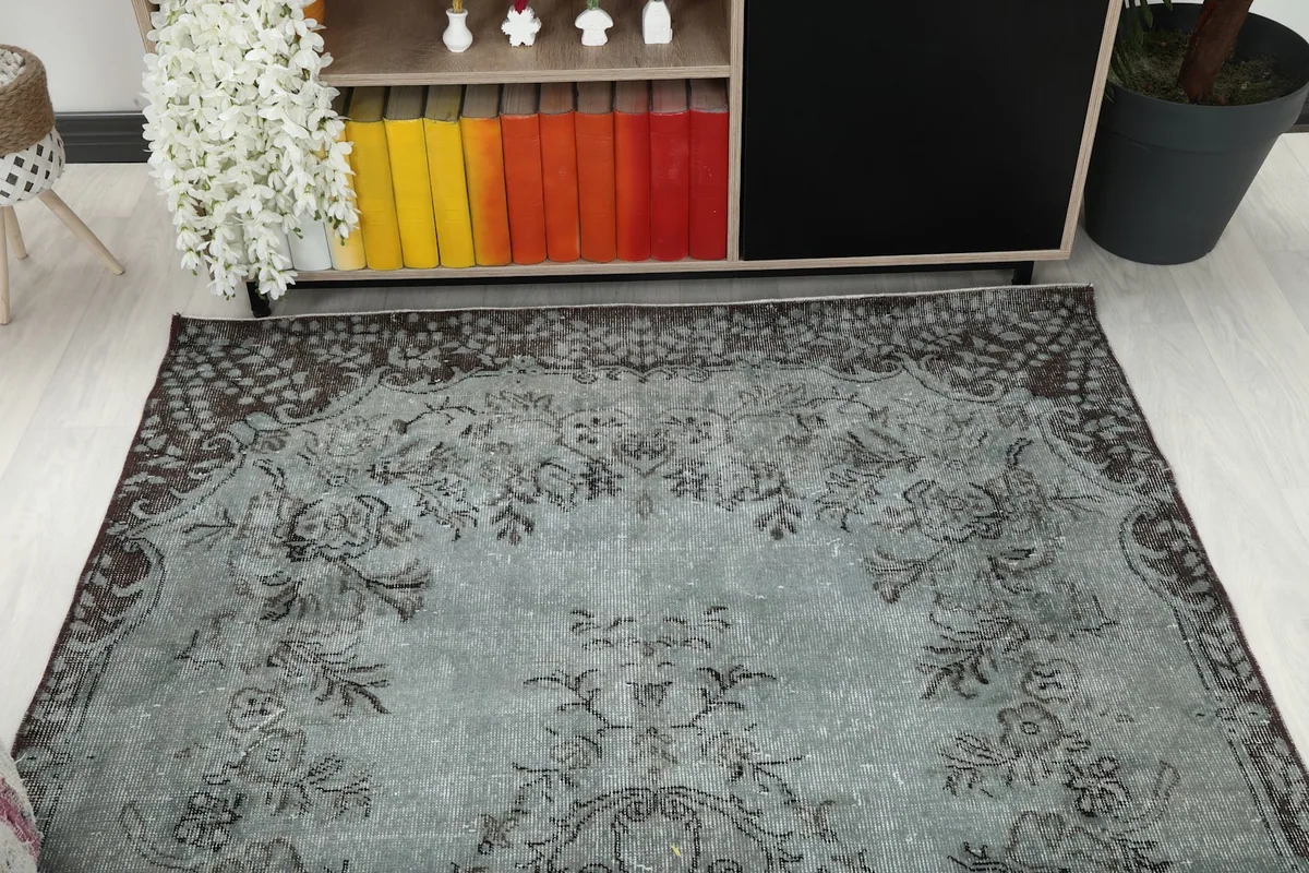 Overhead angle view capturing a section of the blue gray rug's floral design