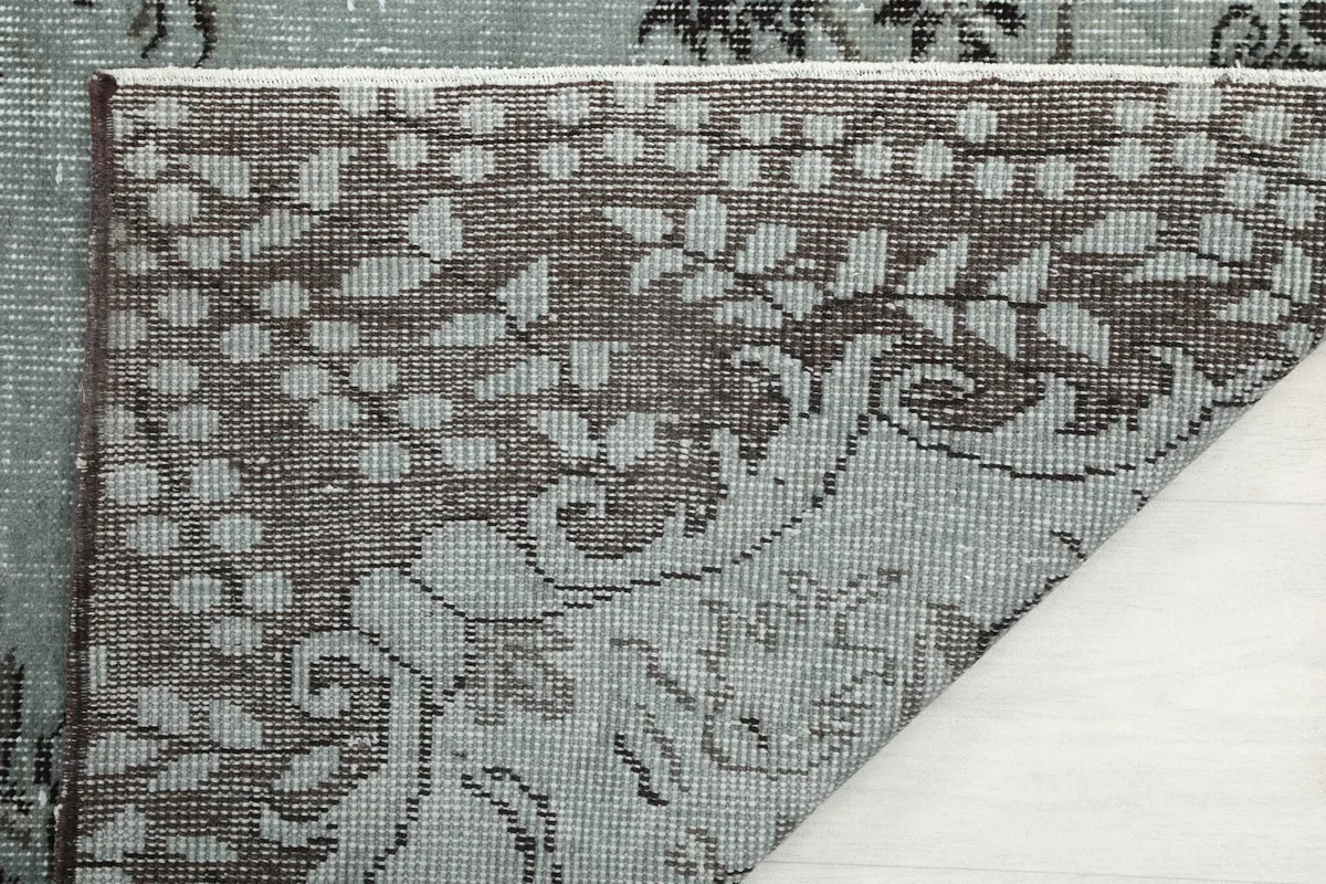 Close-up of the rug's reverse side, showing the tightly woven cotton foundation and knotting