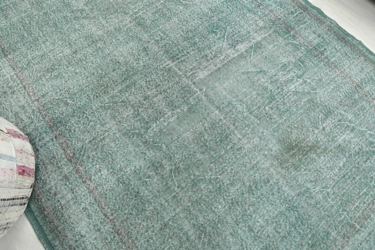 Mid-section detail of the rug, highlighting the worn areas and underlying patterns.