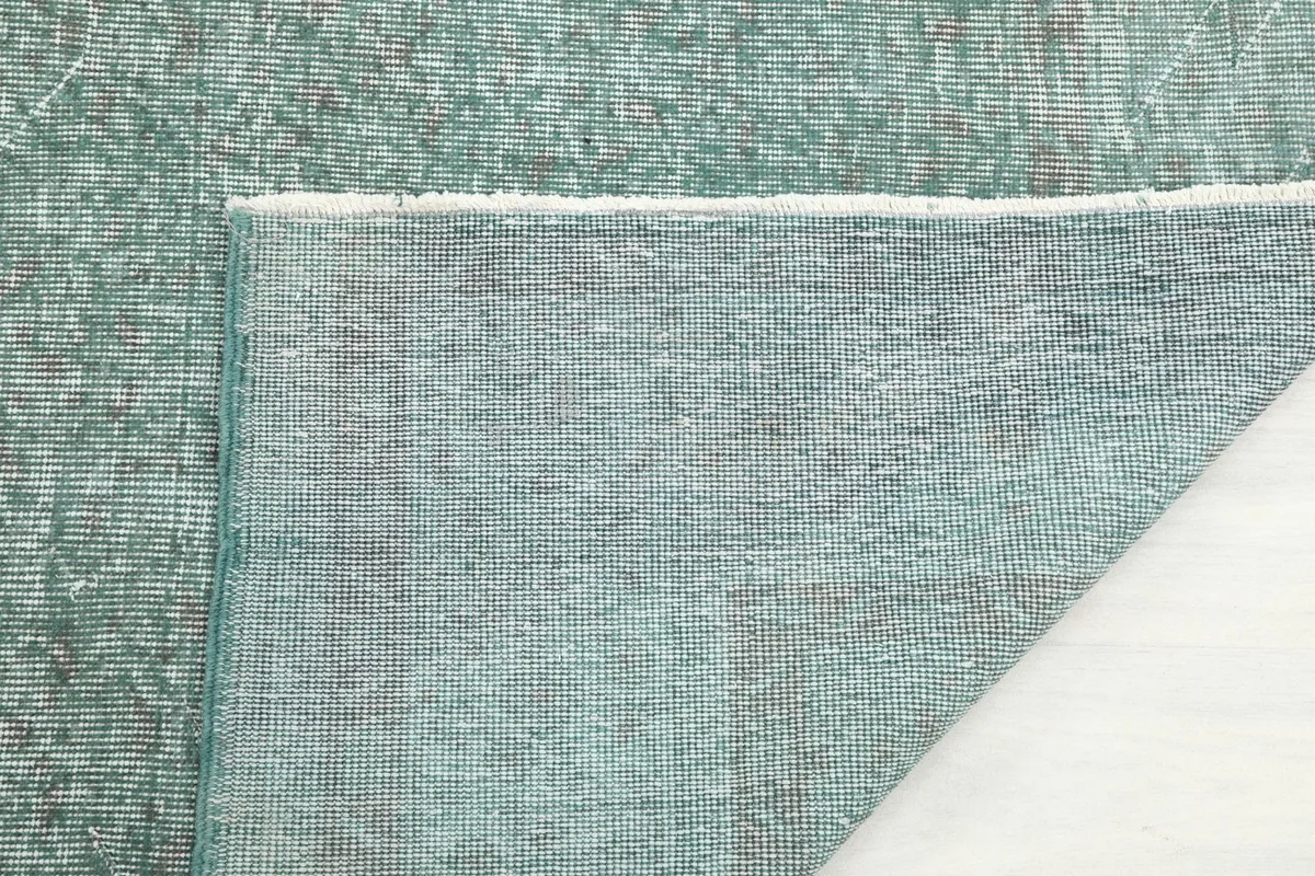 Underside of the rug, showing the cotton foundation and fine hand-knotted construction.