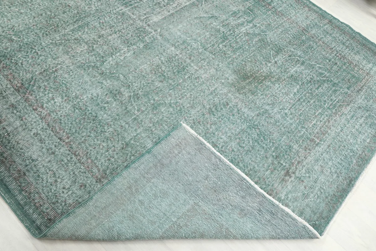 Folded corner of the rug, revealing the thickness of the hand-knotted wool pile.