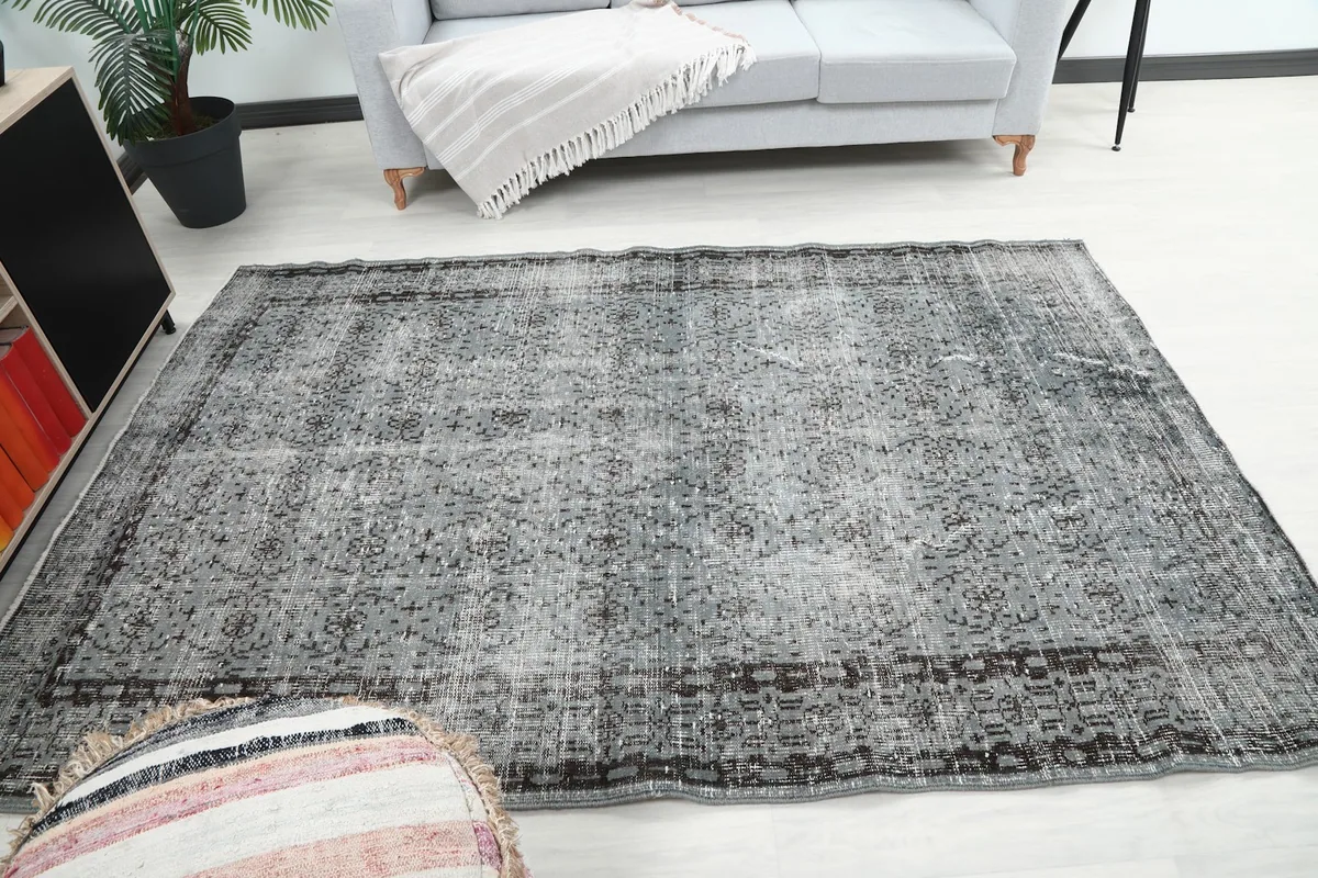 Wide shot of the gray rug in a room, emphasizing its medium size