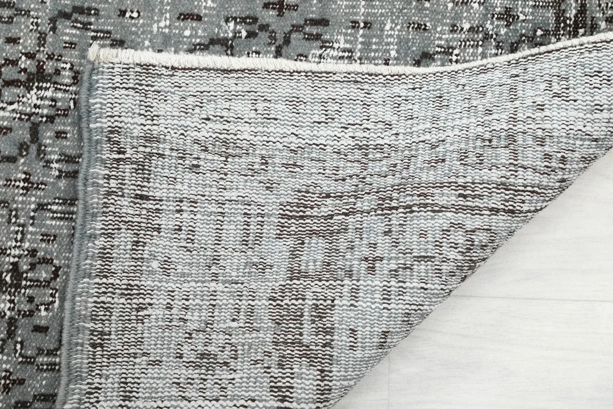 Close-up of the rug's cotton foundation and hand-knotted construction