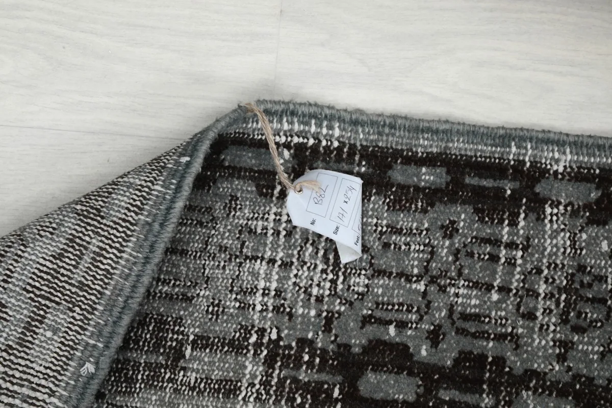 Reverse side of the rug with a size label, showing the hand-knotted detail