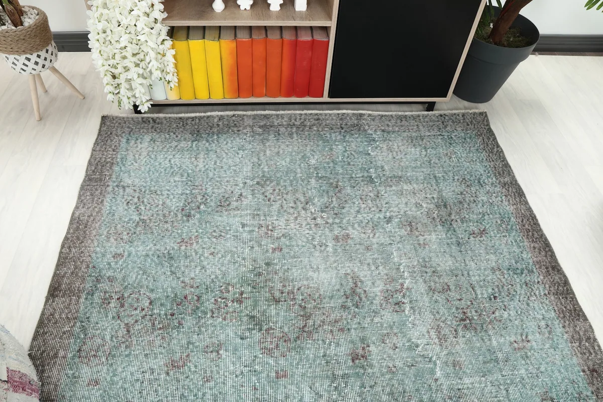 Overhead view of the rug in a room setting, showing its shape and colors in relation to furniture.