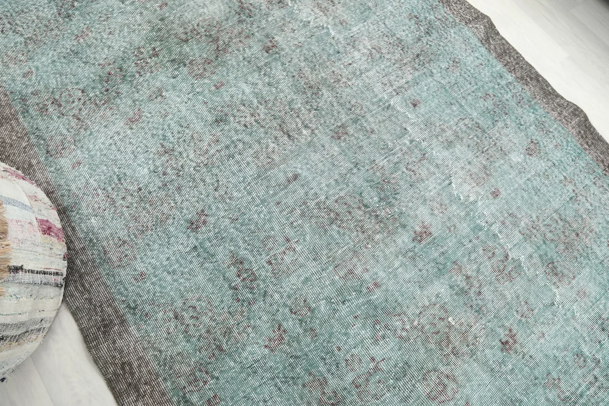 Close-up of the rug's surface, highlighting the subtle geometric motifs and distressed texture.