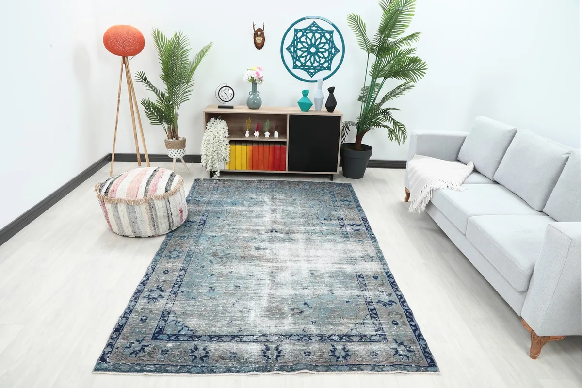 Vintage blue gray rug displayed in a bright living room setup