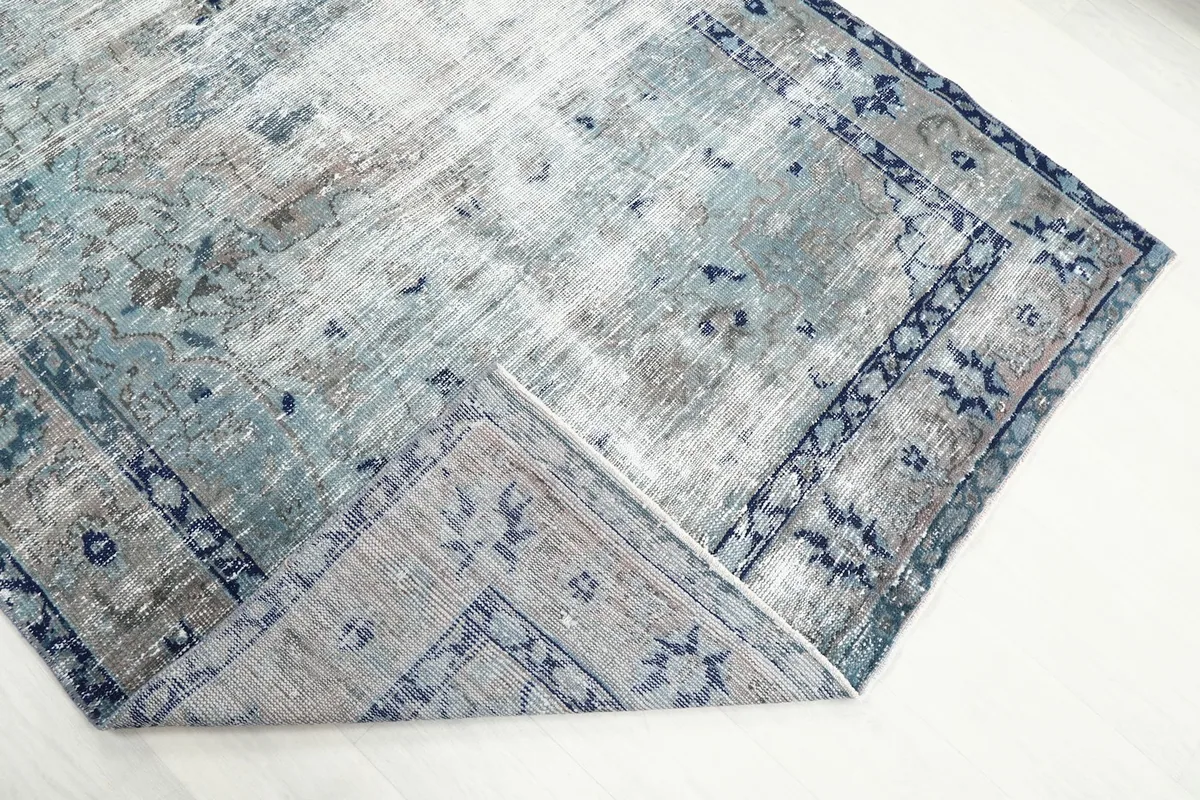 Folded corner of the rug revealing the cotton foundation and reverse side