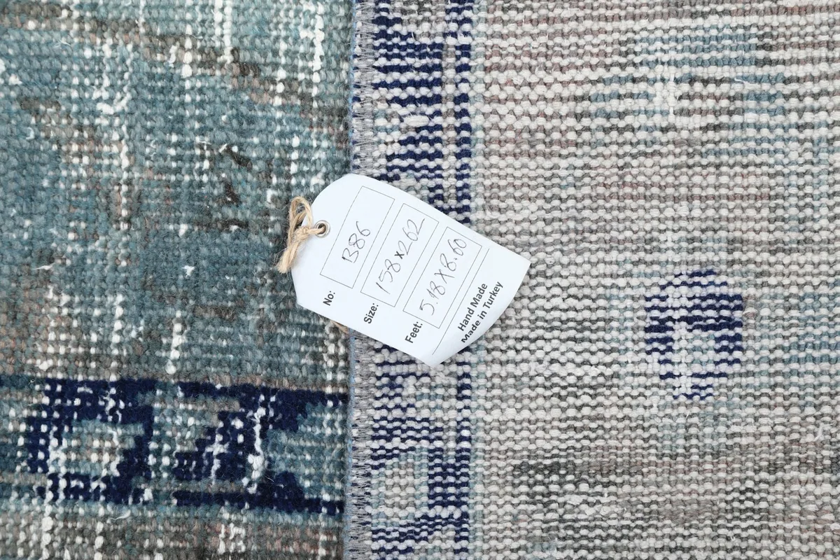 Detail of the rug's label with size information, showing the hand-knotted texture