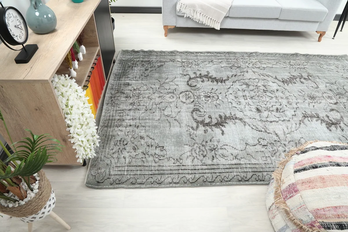 Rug placed in a room, showing its length next to a cabinet and sofa.