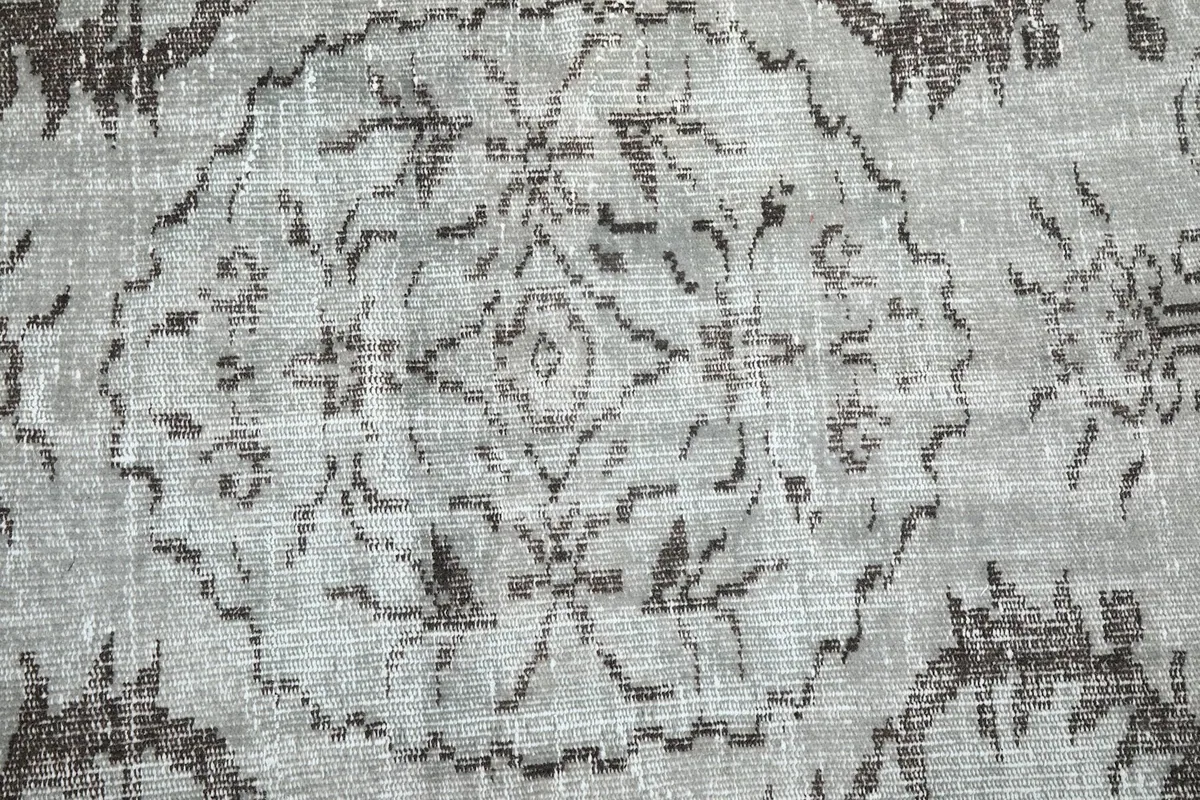 Detailed close-up of the central medallion design with its intricate charcoal patterns.
