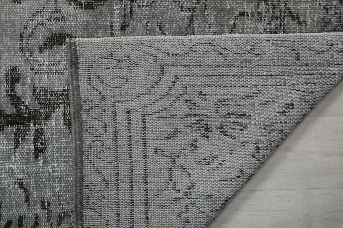 Close-up of the rug's back, showing the cotton foundation and knotting detail.