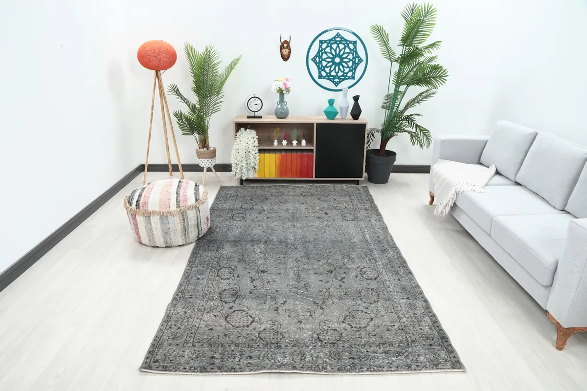 Charcoal gray vintage rug in a modern living room setting with a light sofa and colorful decor
