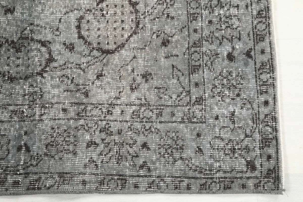 Detailed view of the rug's border and corner, showing the hand-knotted texture and patterns