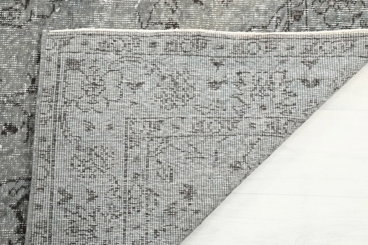 Close-up of the rug's reverse side, showing the intricate hand-knotting on the cotton foundation