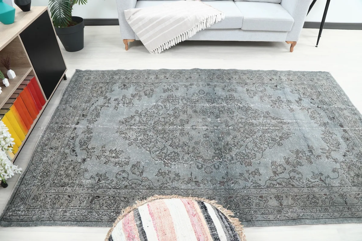 Blue and gray vintage rug in a living room, viewed from a wider angle