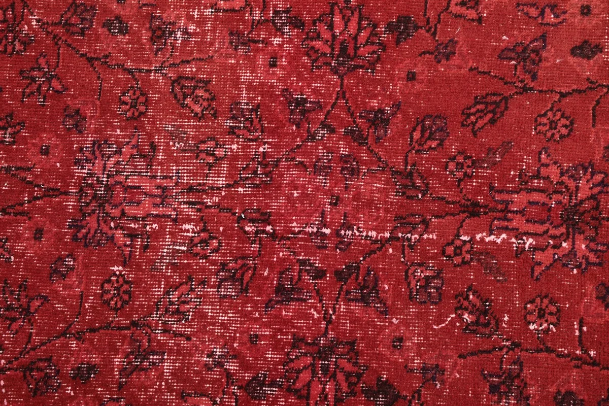 Close-up of the rug's pile showing the intricate floral motifs and patina