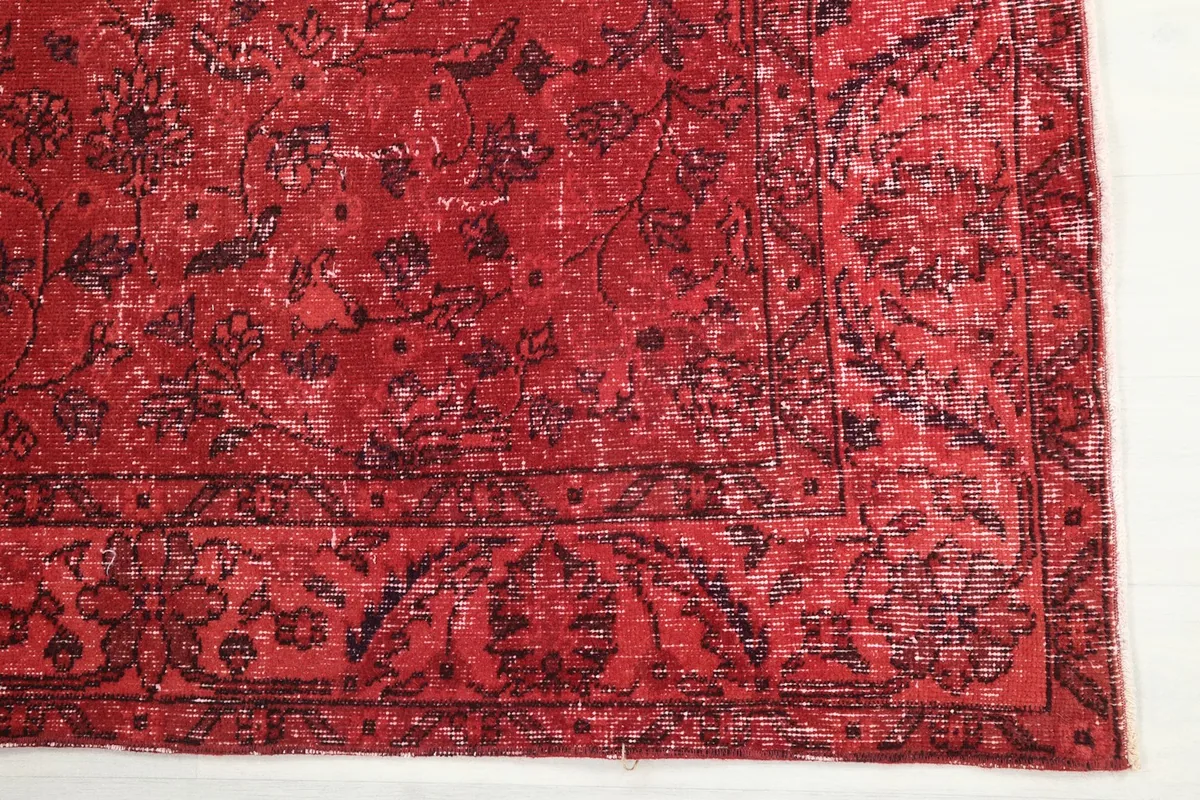Detailed view of the rug's border design and corner with visible wear