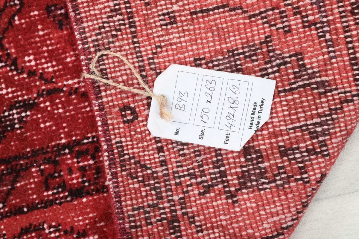 Close-up of the rug's back with a tag indicating origin and dimensions