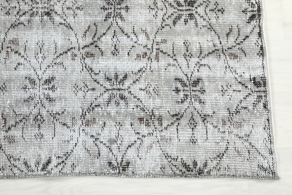 Detailed view of the Gray Floral Anatolian Rug's corner, showing the hand-knotted texture and faded motifs.