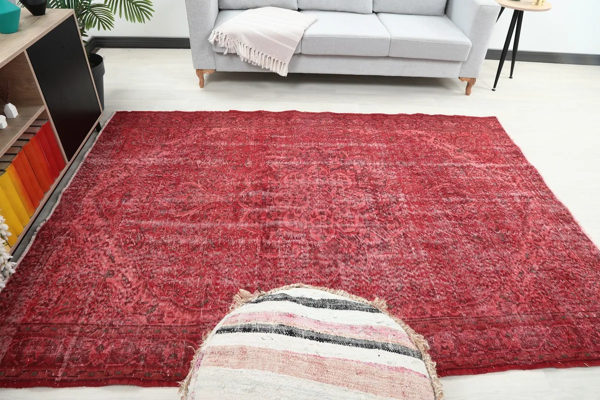 Wide shot of the red vintage rug in a living space, demonstrating its size and visual impact.