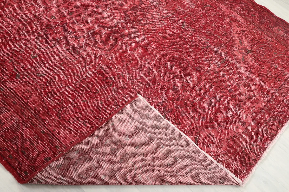 Corner of the rug folded back to show the wool pile on the front and cotton foundation on the back.