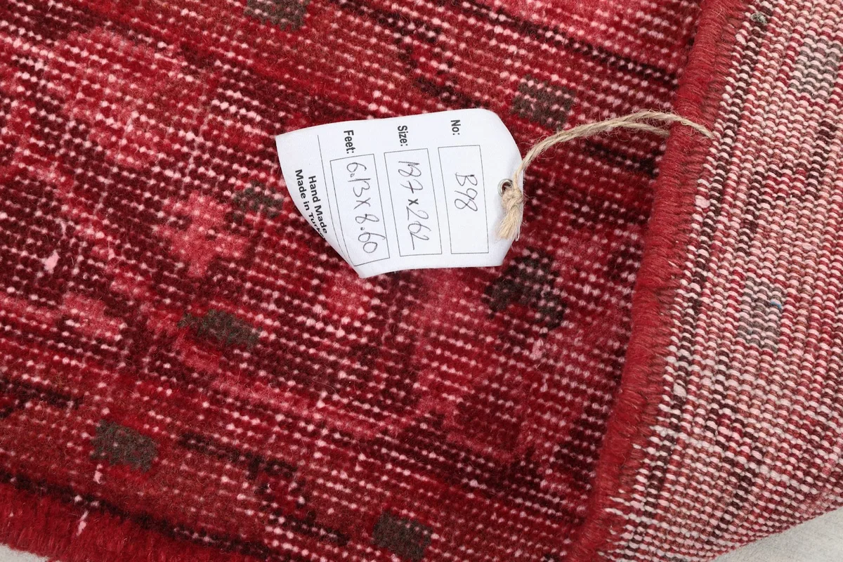 Close-up of the rug's label with size information, showing the hand-knotted texture on the back.