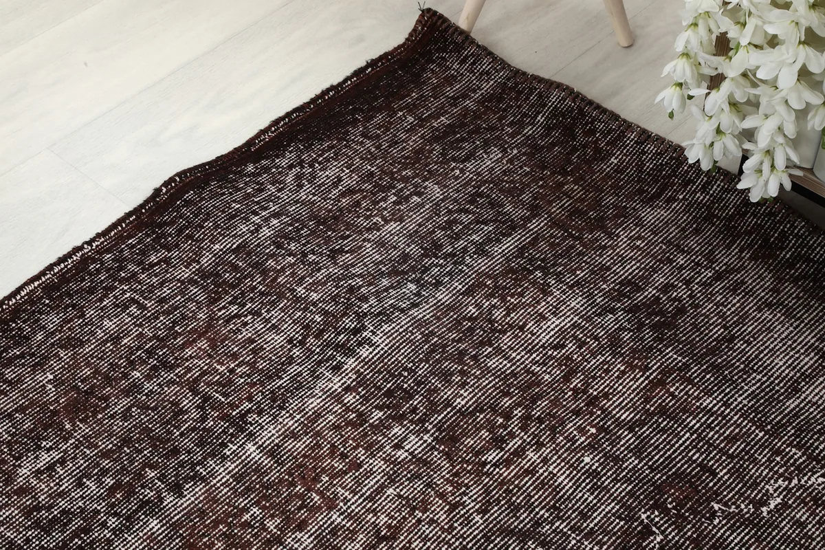 Angled view of the rug's corner, emphasizing its vintage character