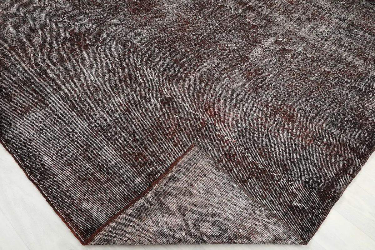 Corner of the rug folded back, revealing the wool pile and cotton foundation