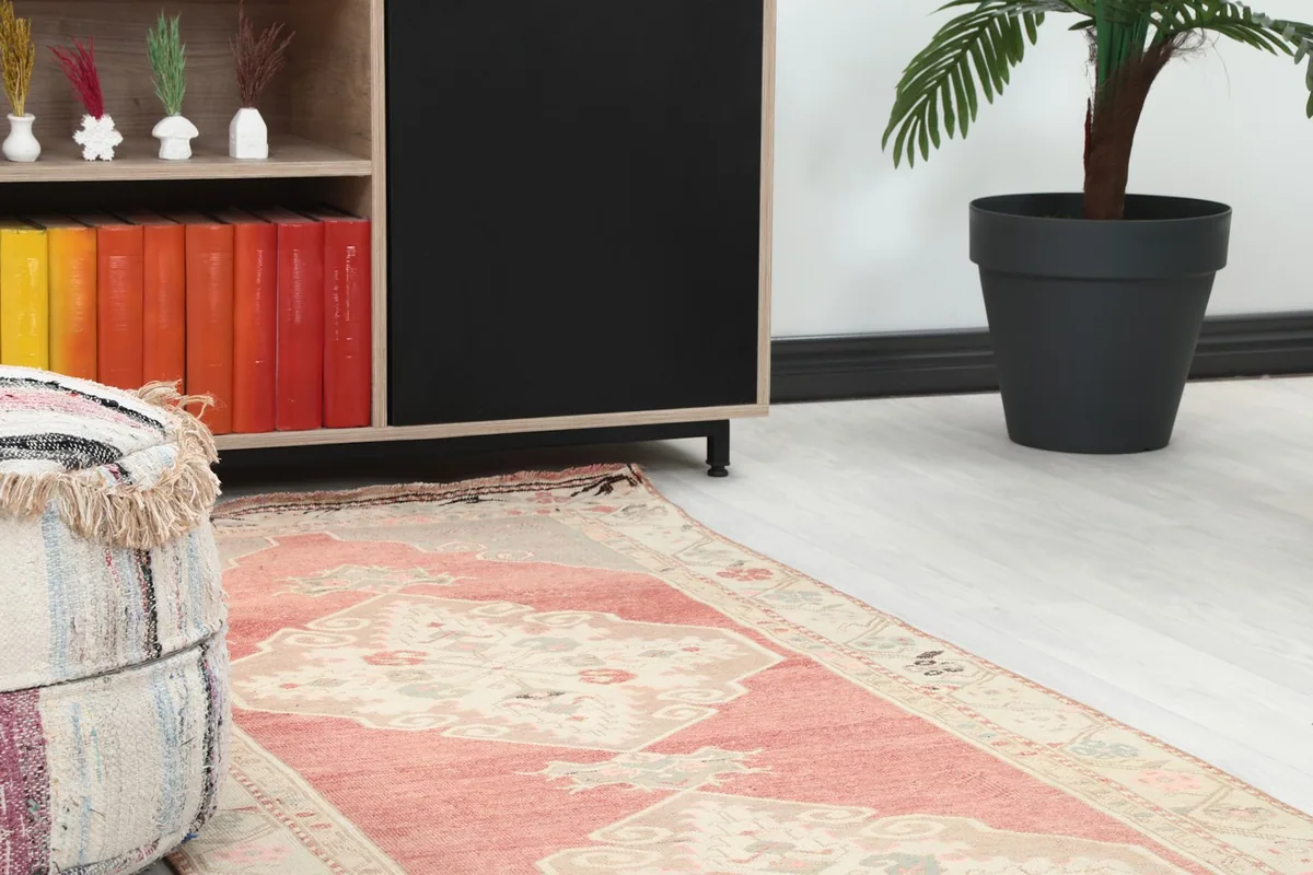Close-up of one end of the runner rug in a room, showing texture near a pouf