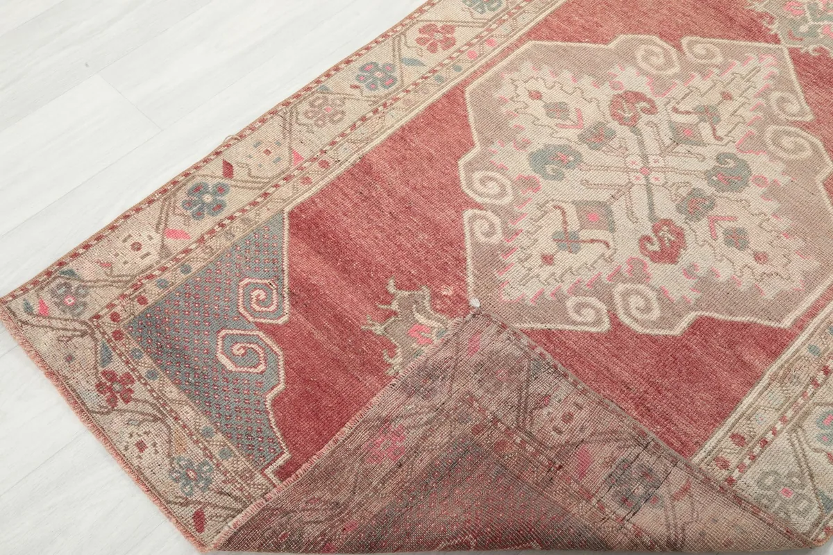 Corner of the rug folded to show the wool pile and cotton foundation from the side
