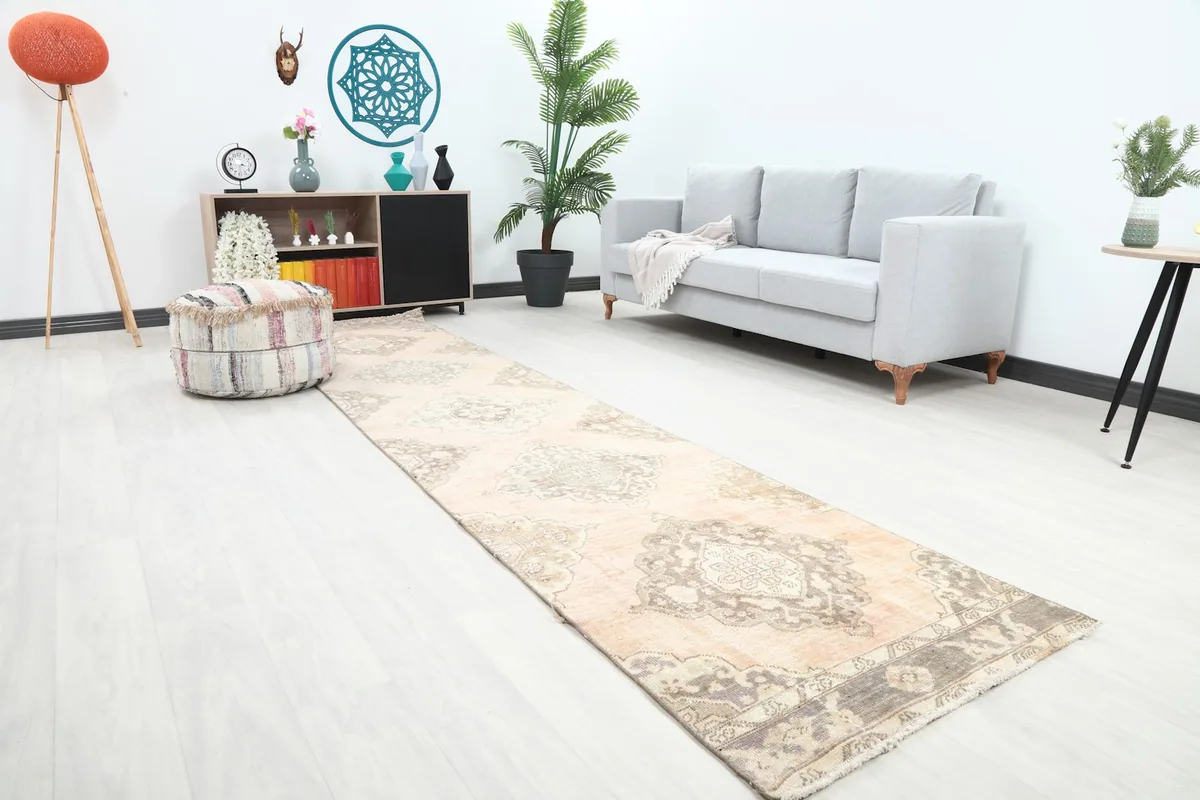 Angled view of the rose and gray runner rug extending into a hallway with contemporary furniture