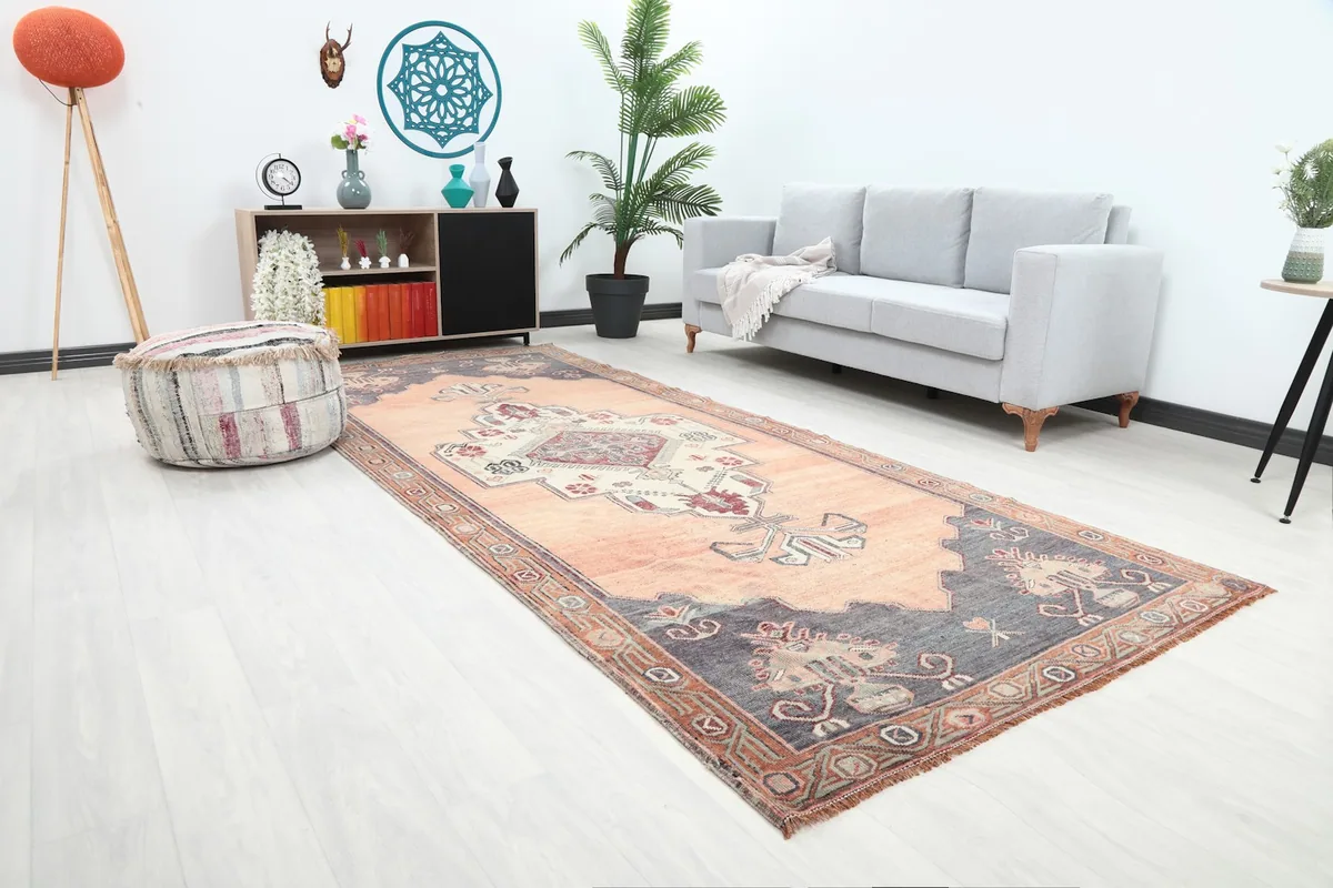 Angled view of the orange tribal runner in a room, showing its length next to a sofa