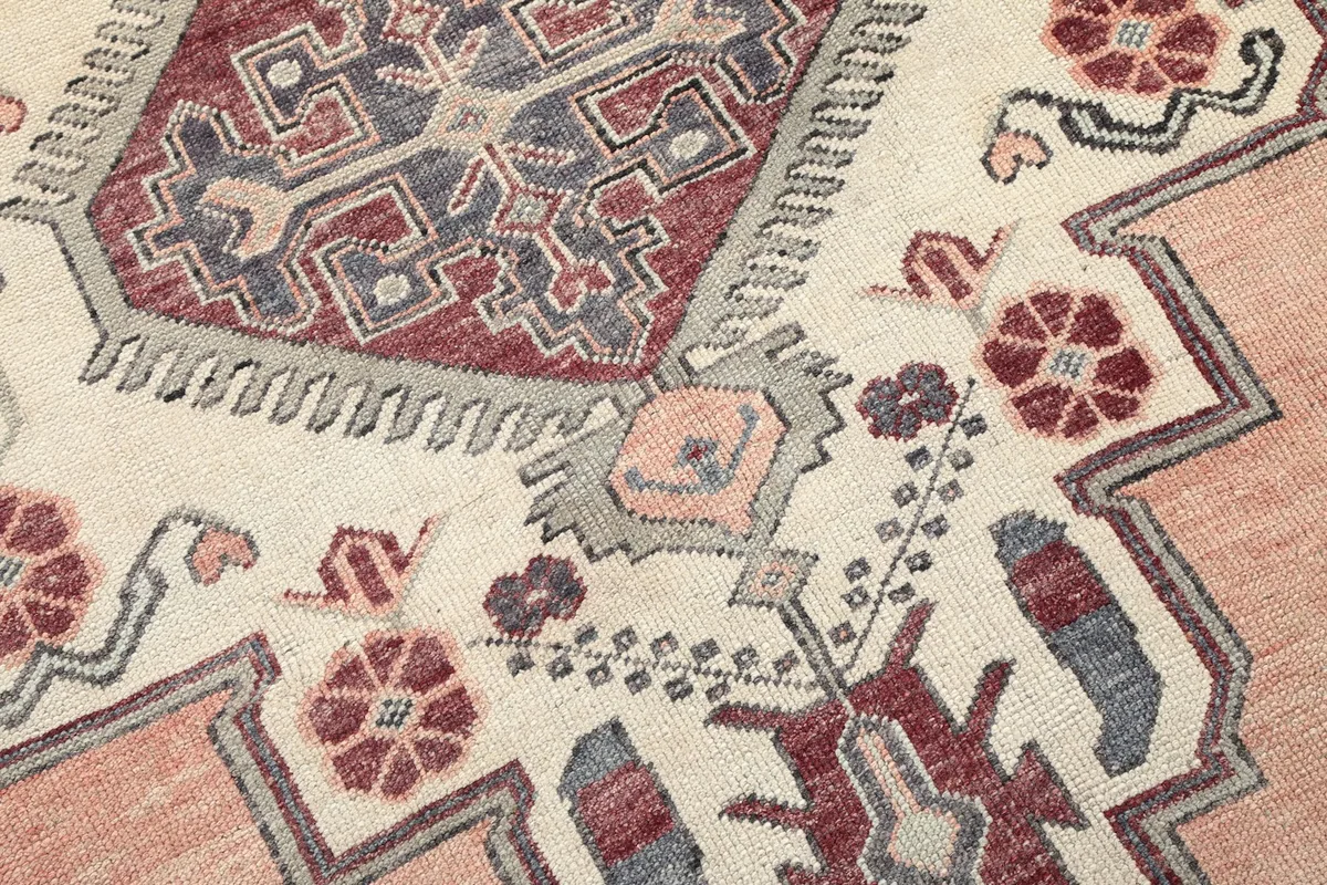 Close-up detail of the ivory field section with red and gray floral and geometric patterns