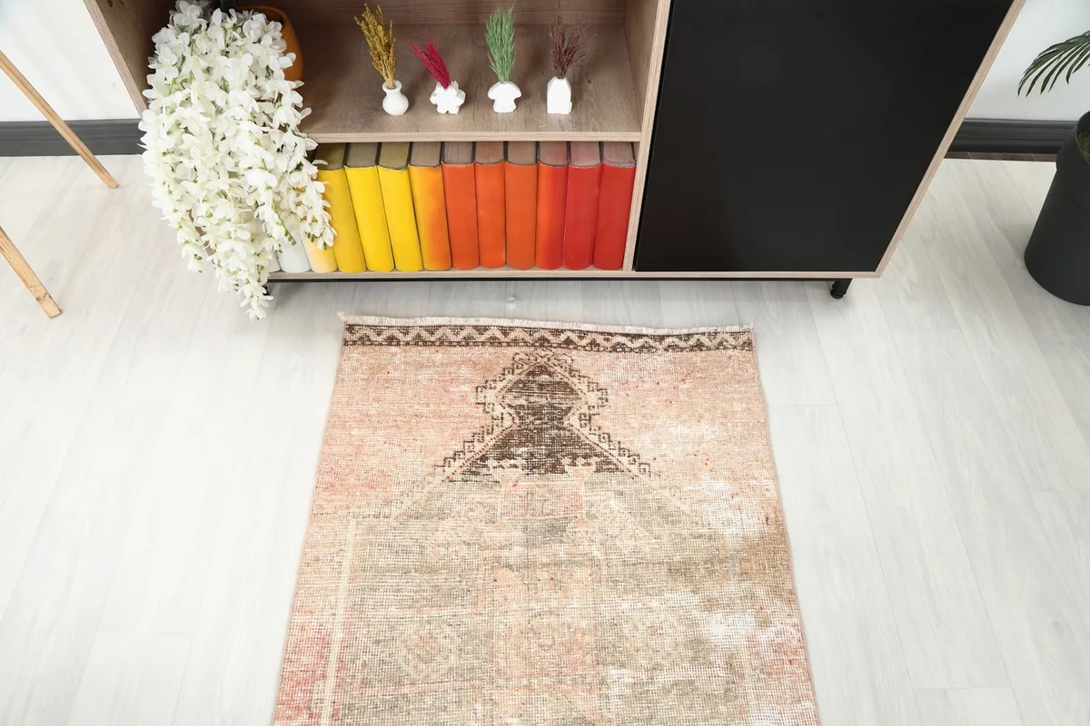 Overhead view of one end of the rose beige runner rug, showing the geometric pattern