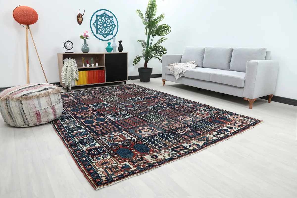Angled view of the hand-knotted rug in a living room, highlighting its colors and texture against a light floor.