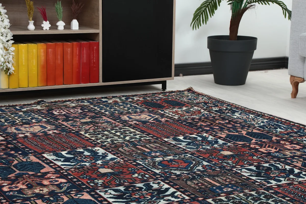 Close-up view of the rug's surface, showing the intricate geometric patterns and color variations near furniture.