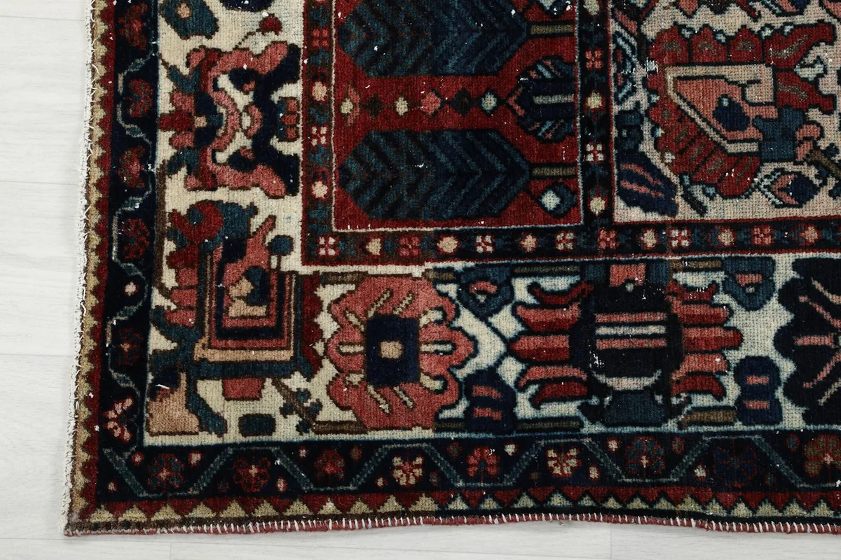 Close-up of the rug's border design and corner, showing the contrasting ivory and navy elements.