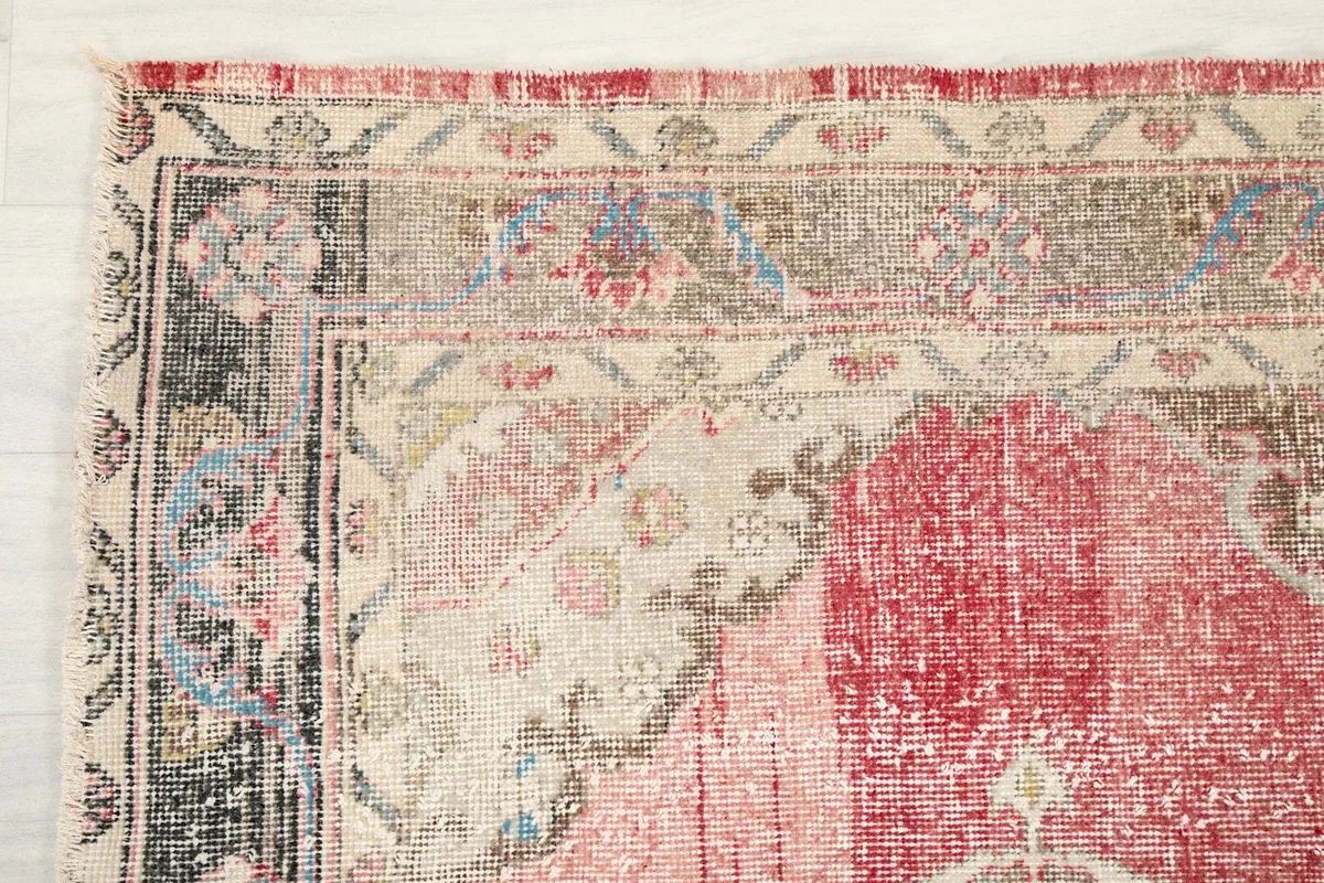 Close-up of the distressed border and corner details with beige, gray, and black