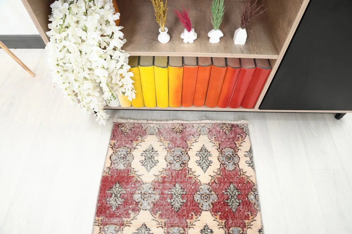 Close-up angled view of one end of the runner rug, showing its patterns and colors near a bookshelf.