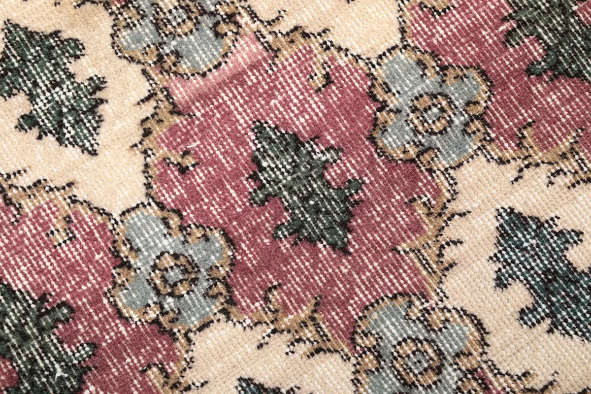 Close-up of the rug's low wool pile, revealing the intricate hand-knotted details and color variations.