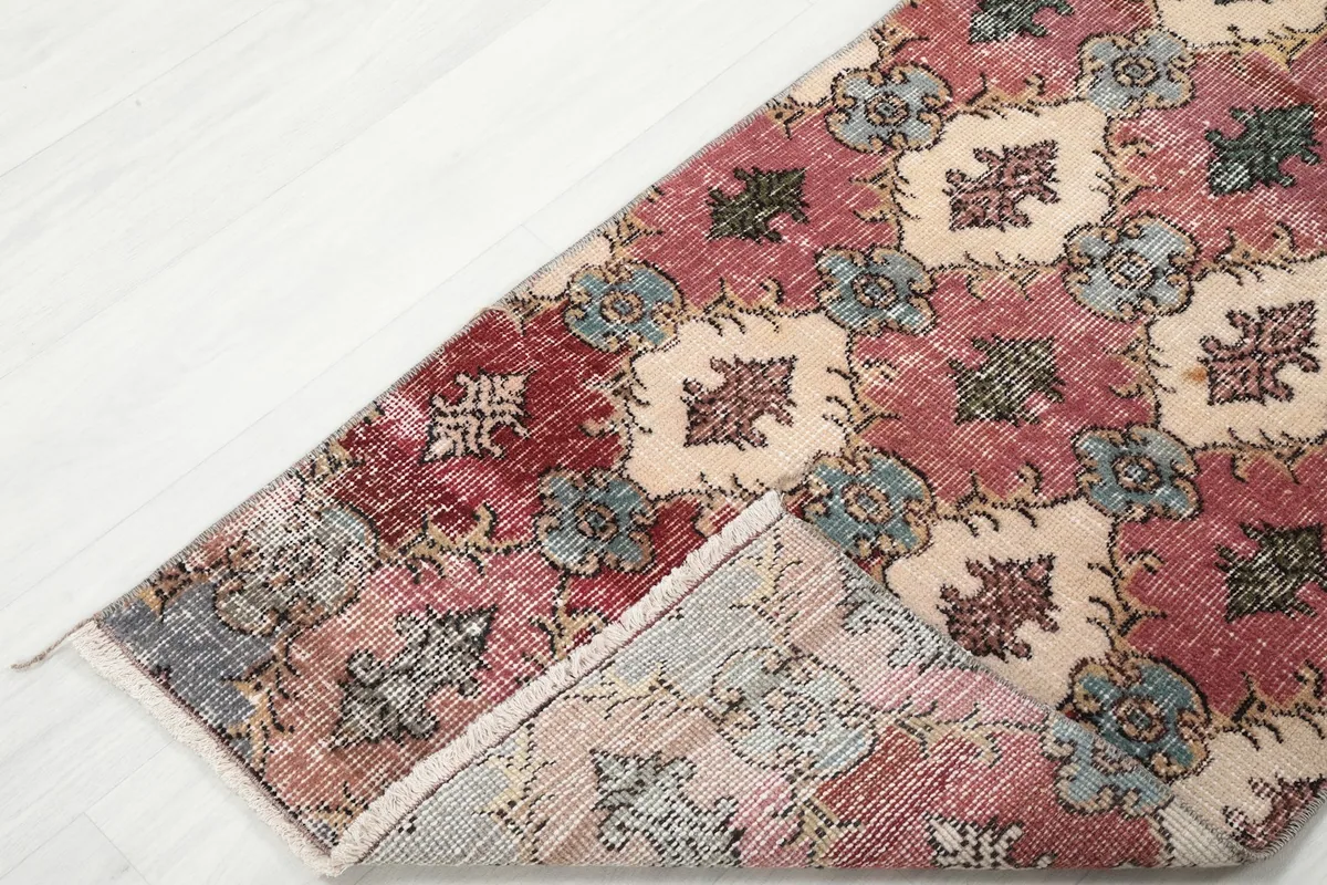 Corner of the runner folded back to show the reverse side and the hand-knotted construction.