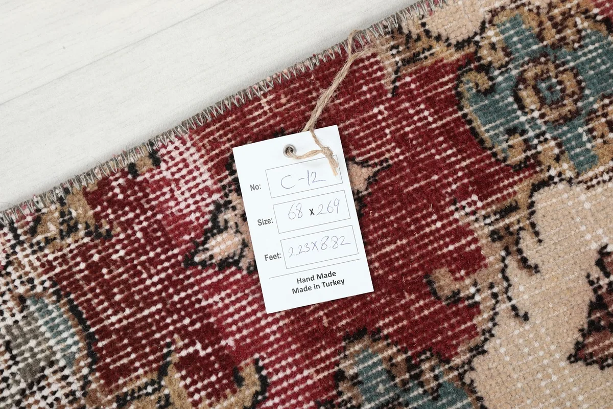 Anatolian runner with a tag displaying its size 2'3" x 8'10" (68 x 269 cm) and origin.